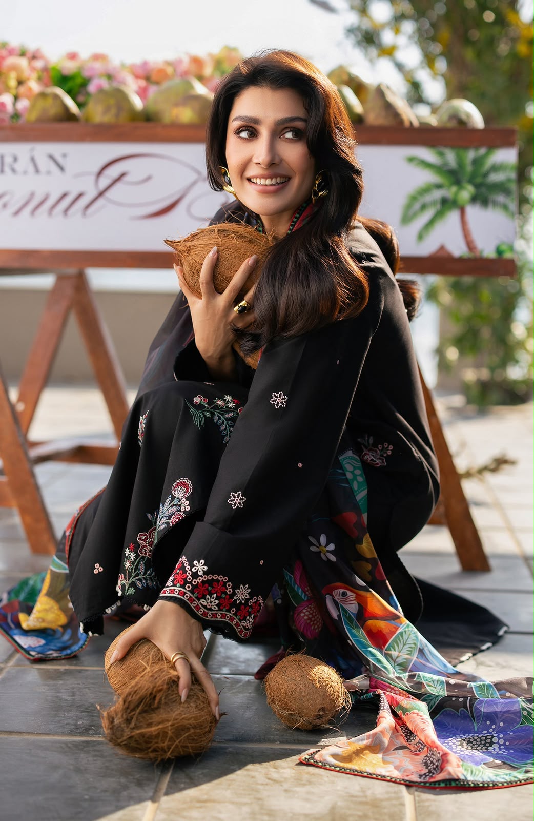 Woman holding coconuts with a colorful backdrop and text