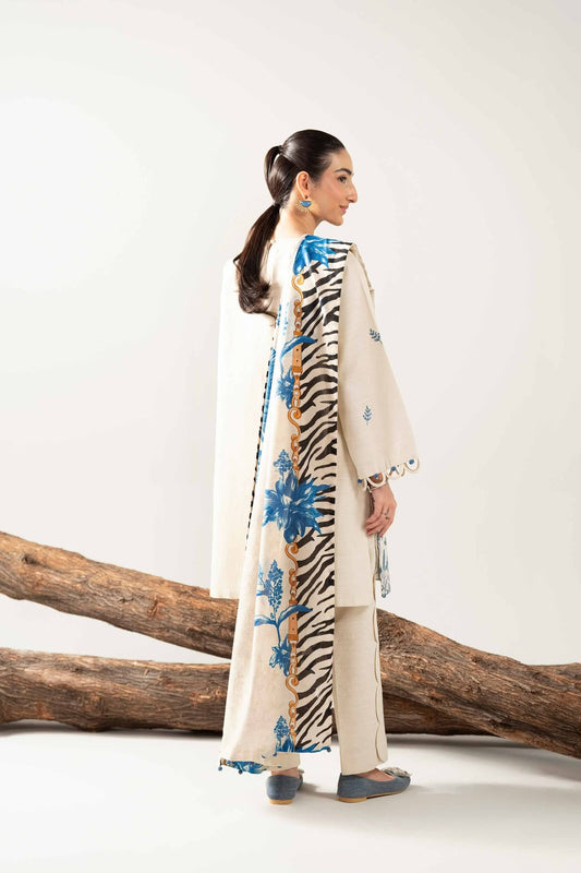 Woman in a stylish outfit with floral and zebra patterned elements, standing next to a wooden log on a white background.