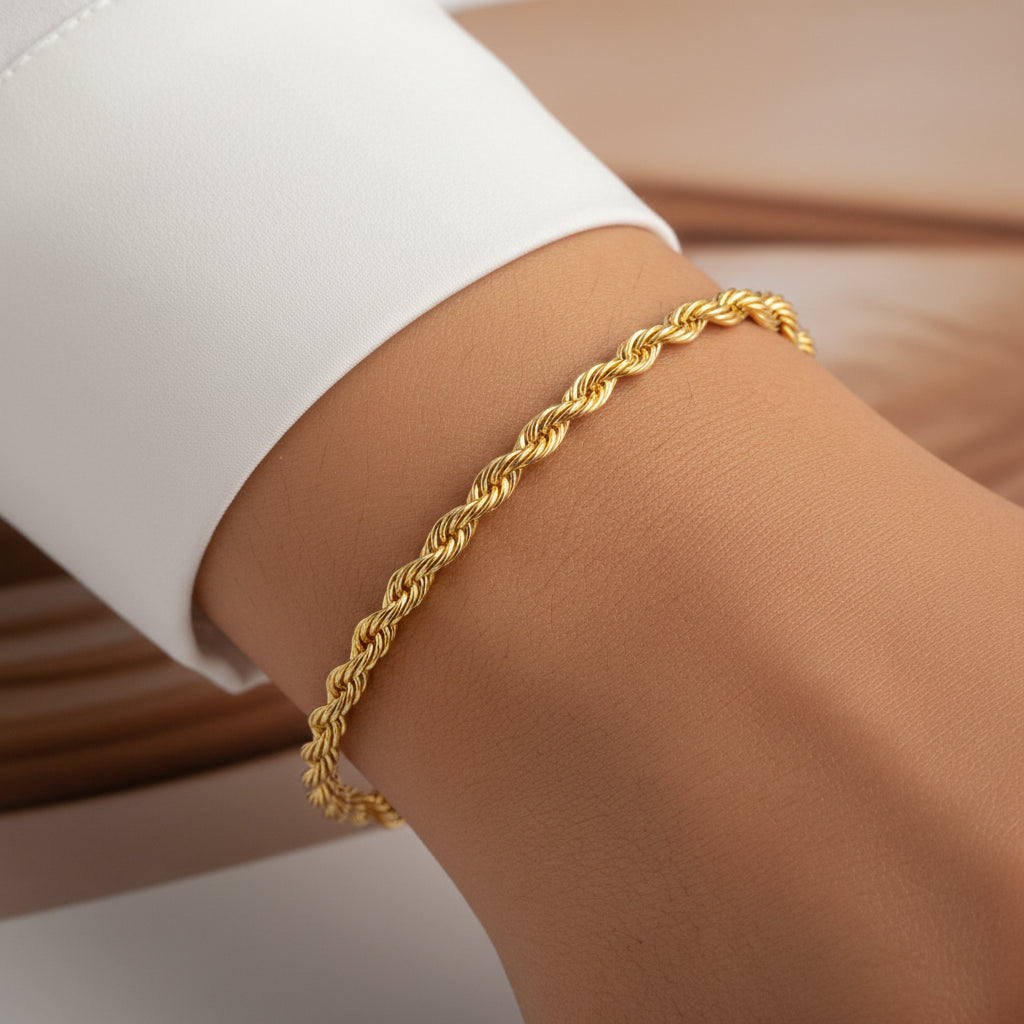 Gold braided bracelet on a wrist with a blurred background