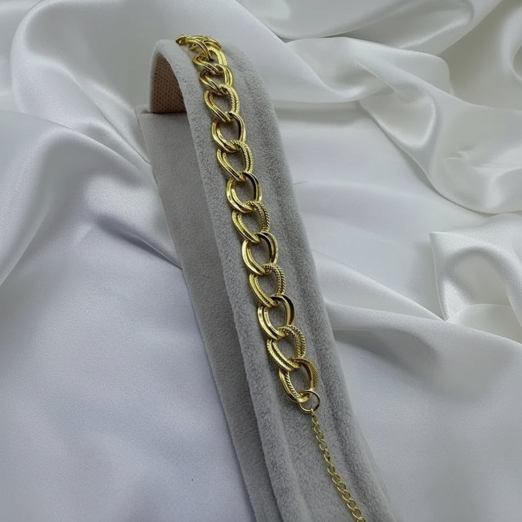 Gold chain on a gray stand with white fabric background