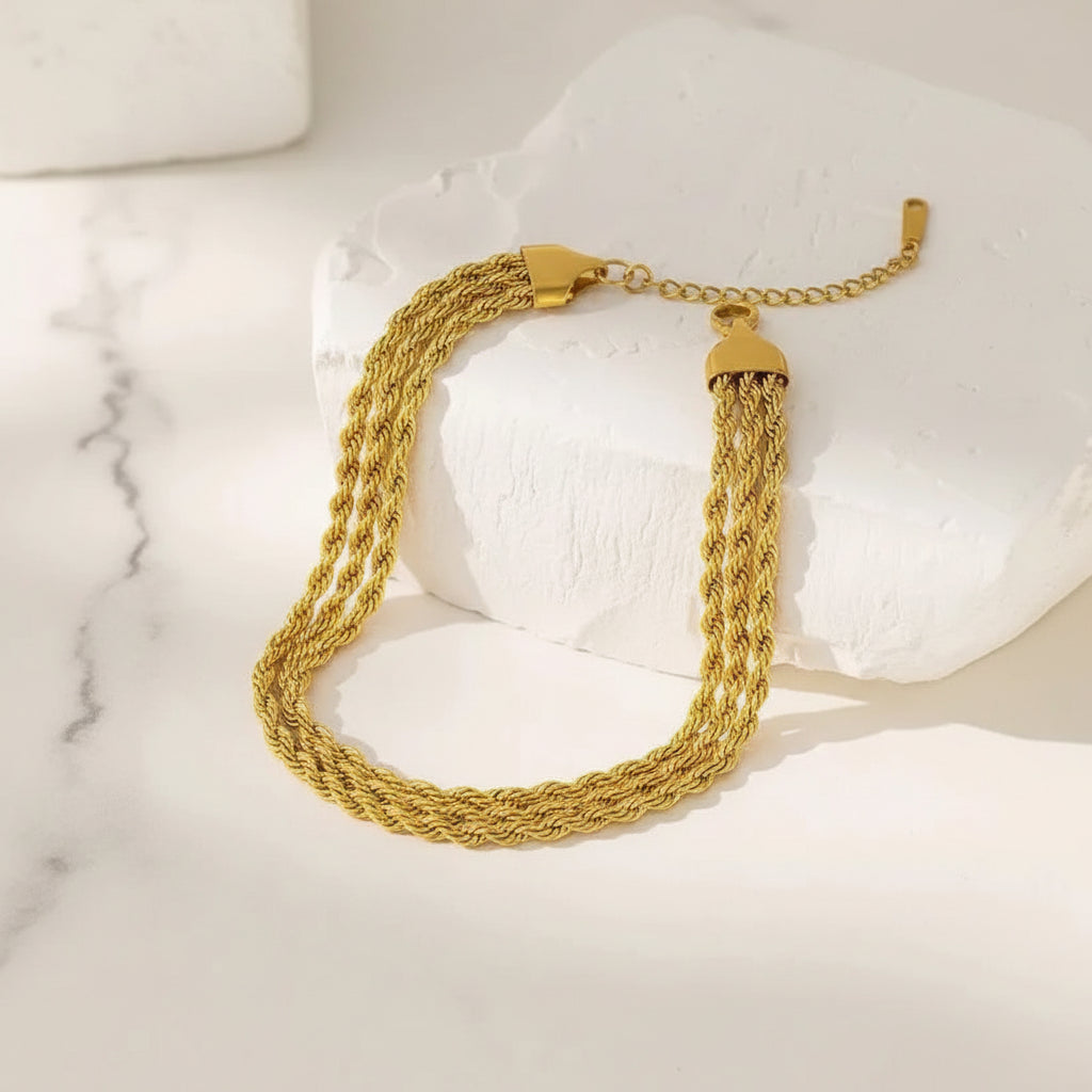 Gold bracelet on a textured white surface