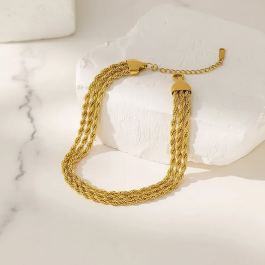 Gold bracelet on a textured white surface