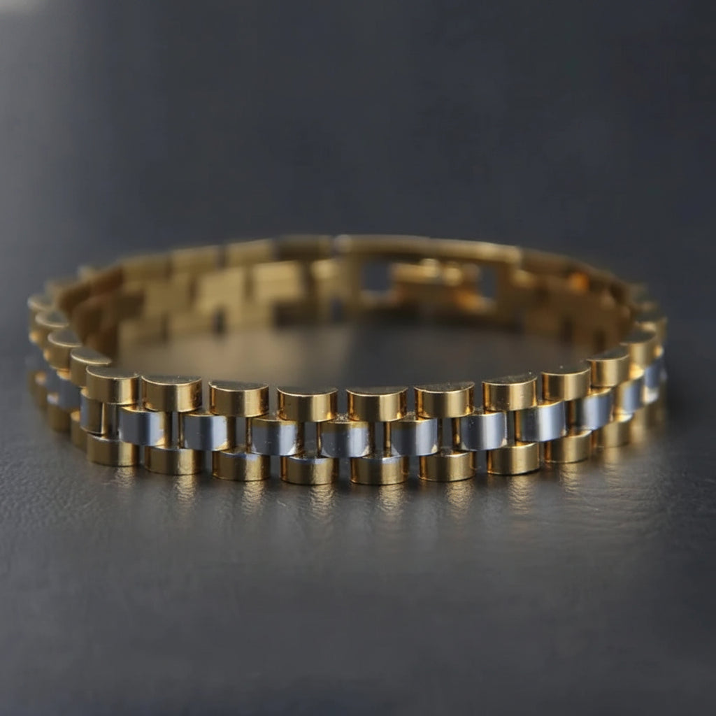A two-tone metal link bracelet with polished gold and silver-colored cylindrical links, displayed on a dark gray surface.