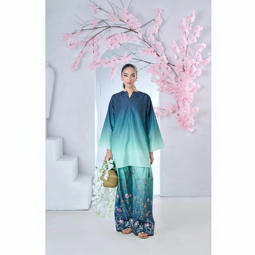 Woman in a gradient dress standing in front of cherry blossom branches.