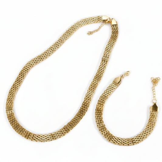 A gold-toned woven mesh chain necklace and matching bracelet displayed on a white fabric background.