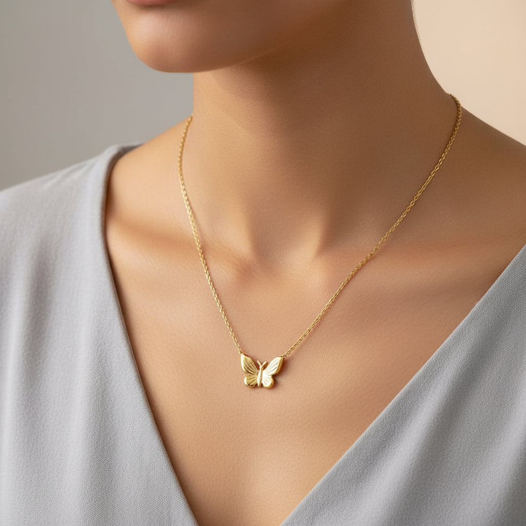 Gold butterfly necklace on a white box with 'always on the road' text