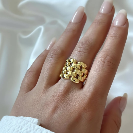 Gold chain ring on a hand with a white background