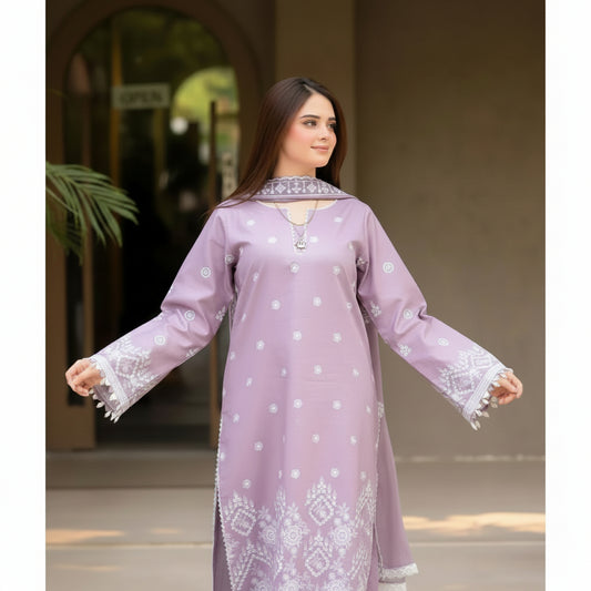 Woman wearing a light purple embroidered dress with white patterns outdoors.