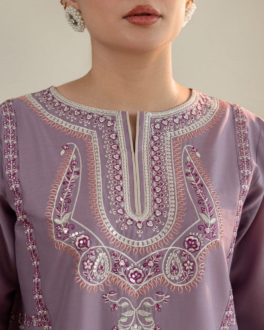 Close-up of a lavender embroidered garment with intricate patterns.