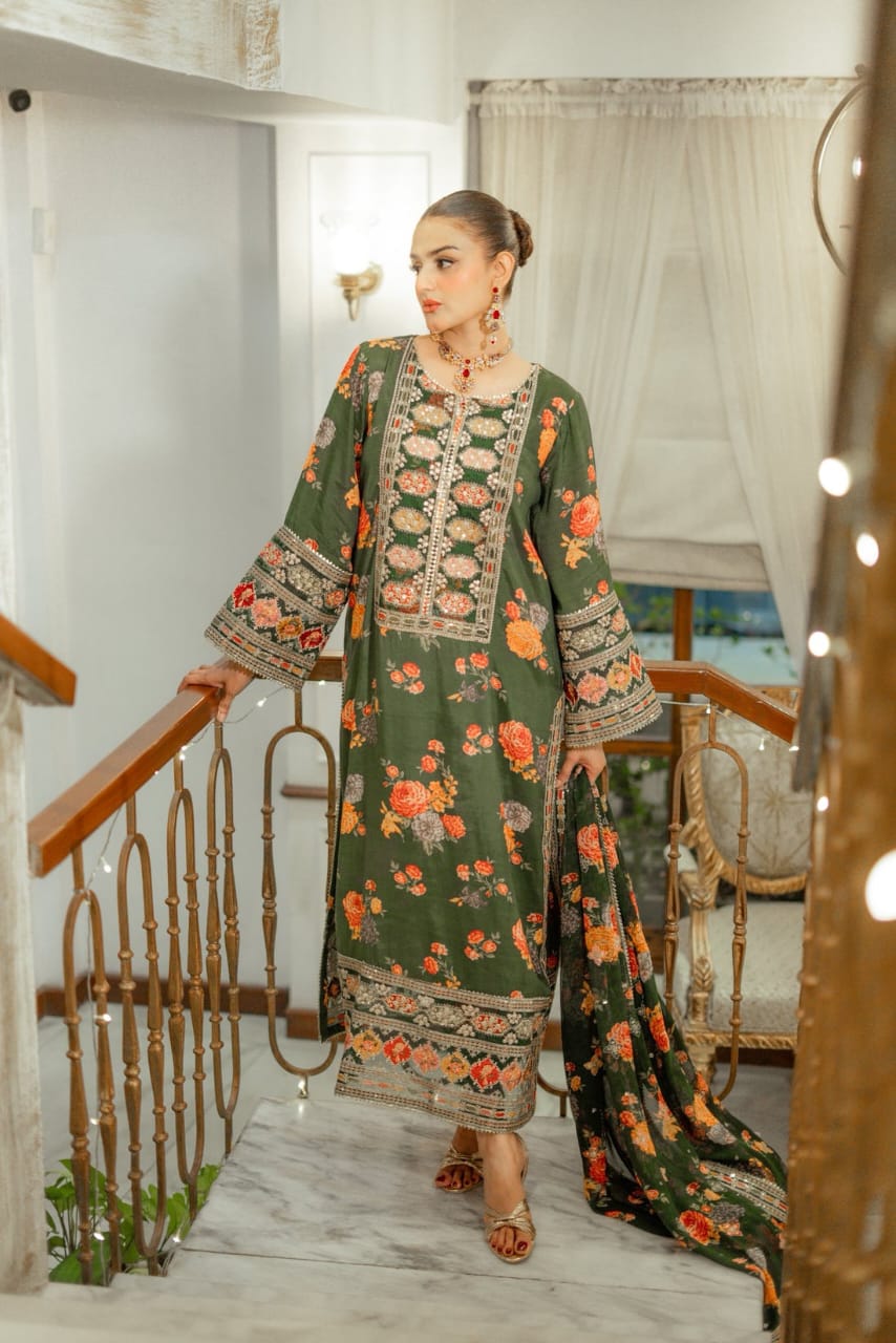 Woman in a green floral dress standing in a decorated room with white walls and wooden furniture.
