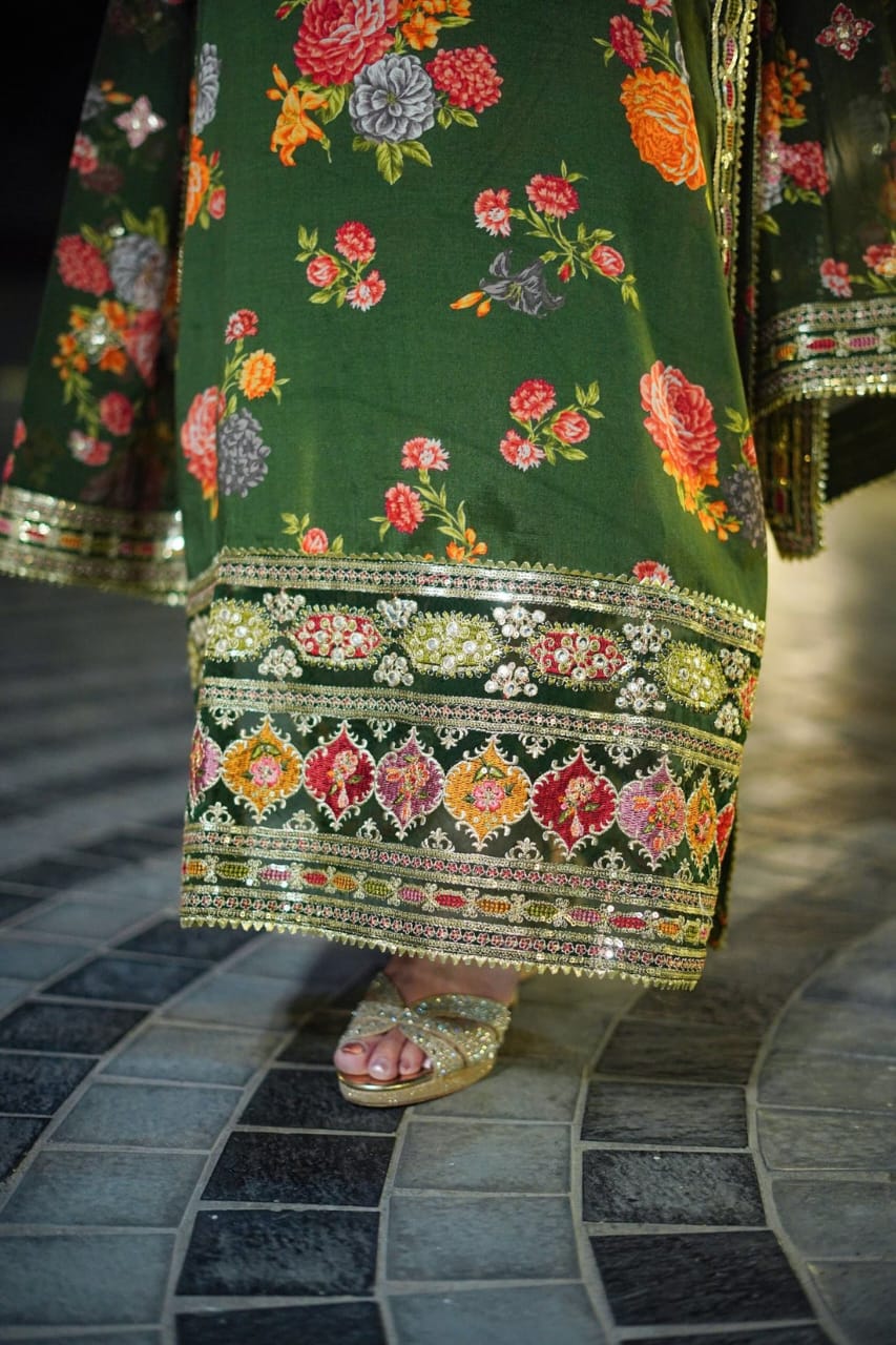 Green traditional outfit with floral patterns on a tiled floor