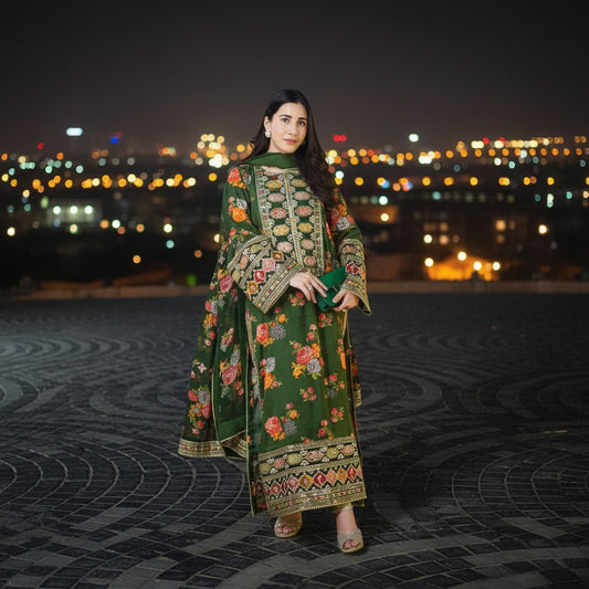 Woman in a green embroidered traditional outfit standing on a tiled pavement at night.