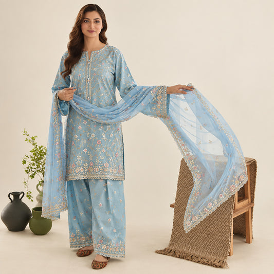 Woman in a light blue traditional outfit with a matching dupatta in a well-lit room.