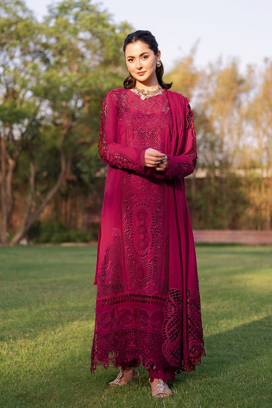 Woman in a red traditional outfit standing outdoors with greenery in the background