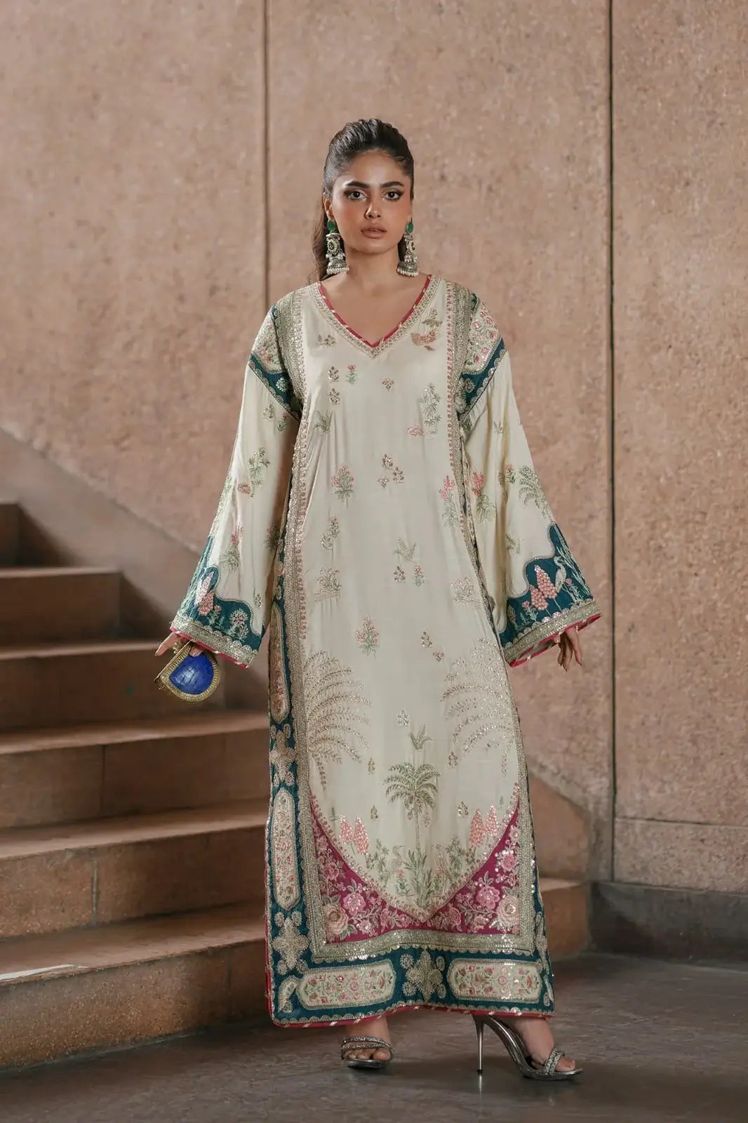 Woman in a traditional embroidered dress standing on a staircase.