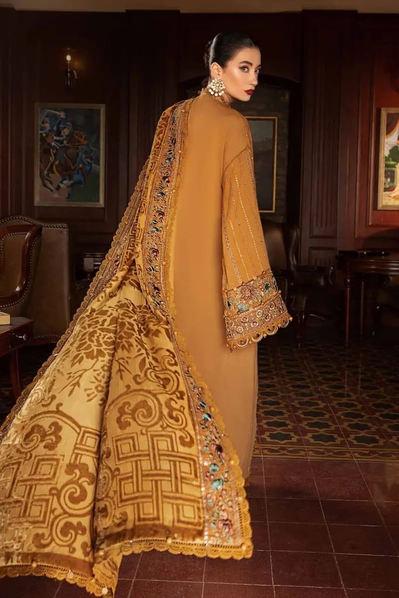 Woman wearing a mustard yellow embroidered outfit in an indoor setting.