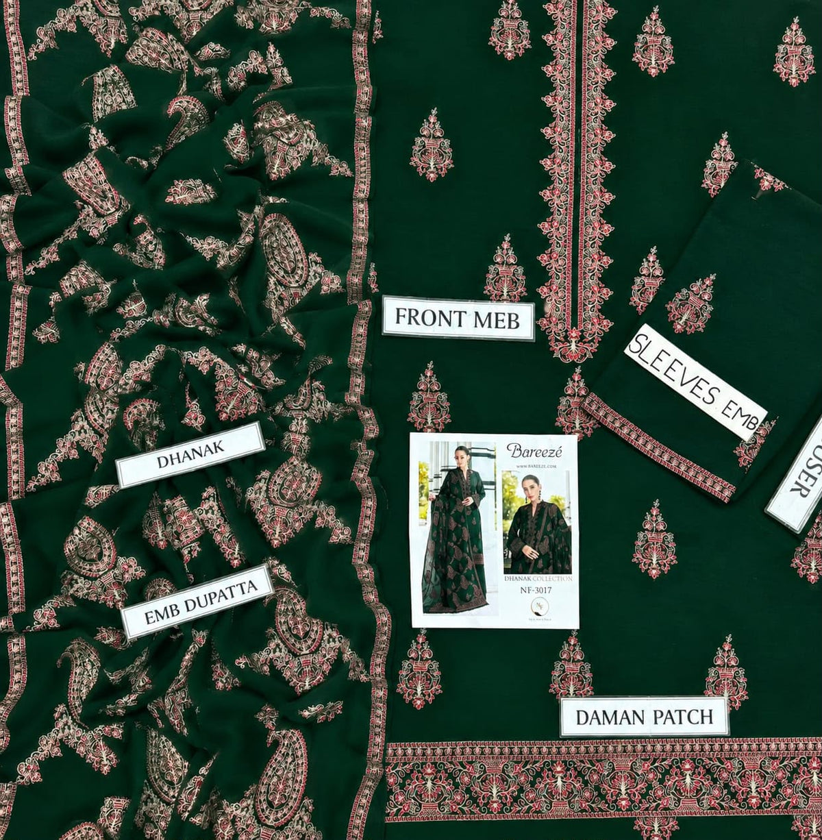 A flat-lay presentation of a dark green ethnic salwar suit fabric set, featuring a printed front meba, sleeve, dupatta, and embroidered daman patch. The fabric has intricate pink and gold floral and paisley patterns.