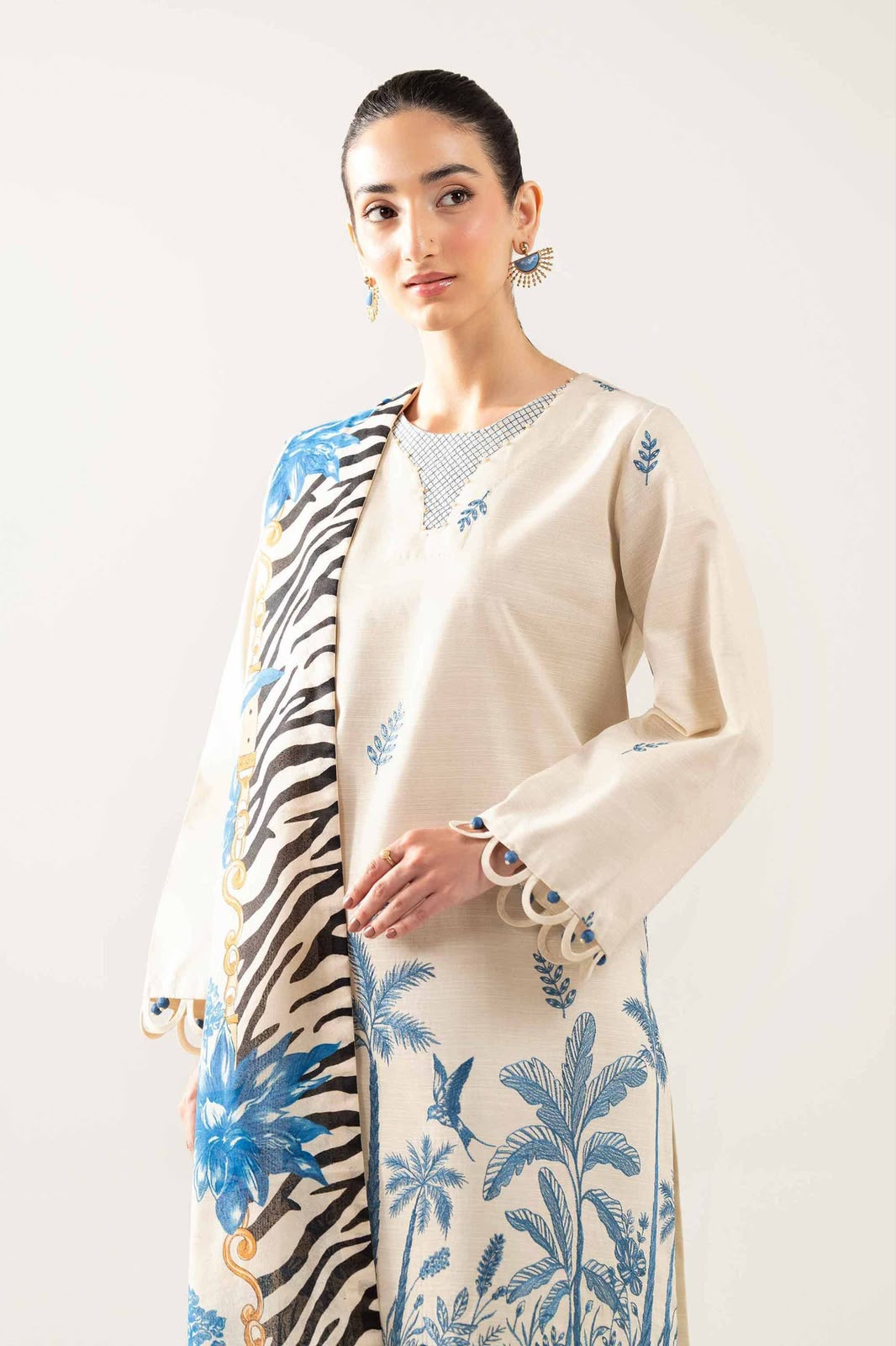 Woman wearing a cream-colored cardigan with zebra pattern and floral embroidery on a white background