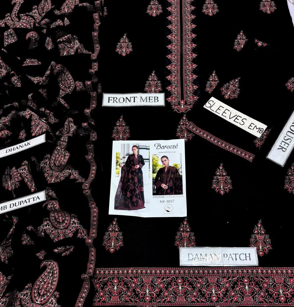 Black fabric garment or dress pattern layout with ornate red and gold embroidered motifs, labeled parts such as FRONT MEB, SLEEVES EMP, DAMAN PATCH, and HR DUPATKA, plus a small printed pattern sheet showing a model wearing the garment.