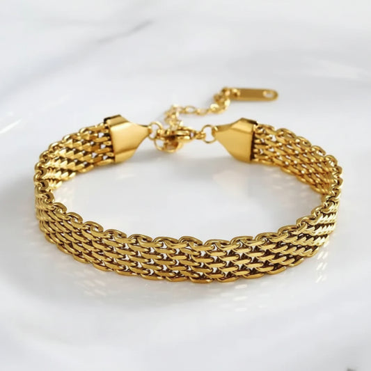 A gold-toned multi-strand chain link bracelet with a triangular clasp and extender chain, displayed on a white reflective surface.