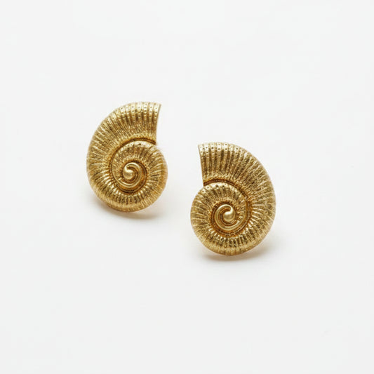 A pair of gold spiral shell-shaped earrings with a textured, ribbed surface, displayed on a white background with a partial black Zara logo in the top right corner.