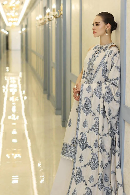 Woman in a white and blue patterned dress standing in a hallway.