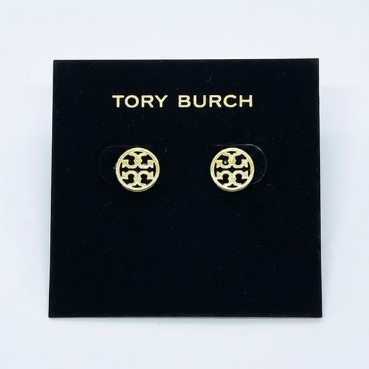 A pair of gold-tone Tory Burch stud earrings with a circular interlocking monogram logo, displayed on a white brand card.